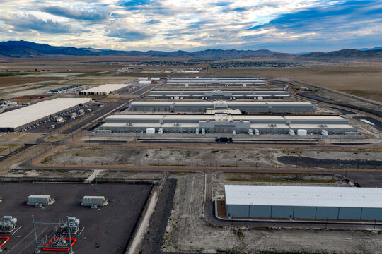 Aerial view of the large-scale data center facility with industrial buildings, paved roads, and electrical infrastructure set against a desert landscape in Eagle Mountain, Utah, United States.