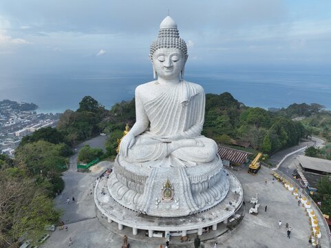 Aerial view of Big Buddha Phuket, a large white marble statue overlooking the coastline with lush green hills and the sea in the background Karon, Phuket, Thailand.