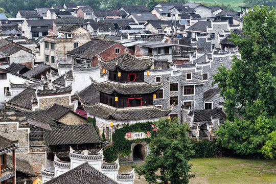 Aerial view of the historic gate tower and traditional wooden architecture of Longli Ancient Town, featuring grey tiled roofs and stone walls in Longli, Guizhou, China.