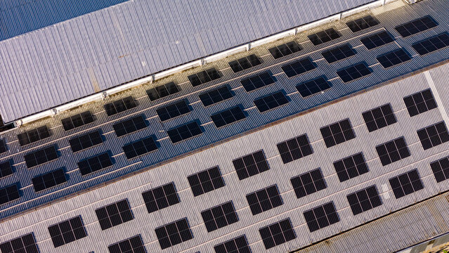 Aerial view of a large industrial roof covered with rows of solar panels in Indonesia.