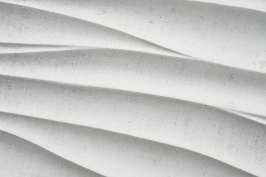 White 3D wave pattern texture background closeup. Modern curved plaster wall surface with smooth shadows and elegant architectural lines, abstract minimalist decorative material for design backdrop.