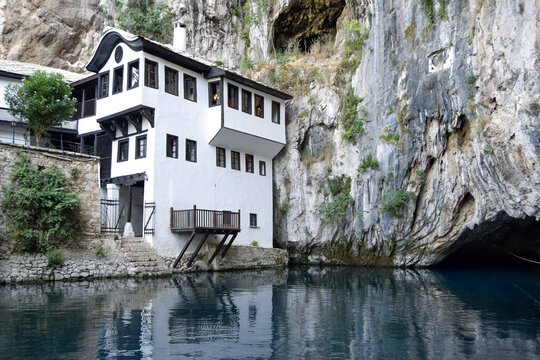 View of the historic Blagaj Tekke dervish monastery nestled against a sheer limestone cliff at the source of the Buna river in Mostar, Federation of Bosnia, Bosnia and Herzegovina.