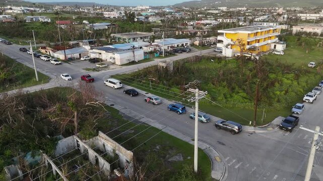 San Jose, Tinian, Northern Mariana Islands - 07 July 2026: Aerial view of a long line of cars waiting at a gas station following fuel shortages caused by super typhoons Bavi.
