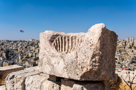 View of the ancient carved stone block at the Umayyad Palace with the cityscape of Amman in the background, Amman, Amman Governorate, Jordan.