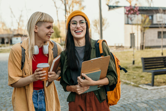 Diverse students walking on campus laughing and smiling