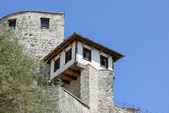 View of the historic stone Tara Tower and traditional Ottoman-style architecture with white walls and wooden frames in Mostar, Federation of Bosnia, Bosnia and Herzegovina.