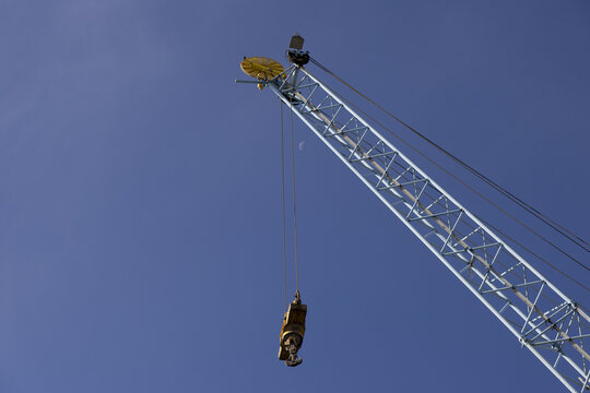 View of a large industrial crane at Kilindini Harbour against a clear blue sky with a faint crescent moon in Mombasa, Kwale County, Kenya.