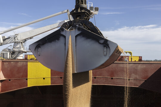 View of a large crane grabber unloading grain into the hold of a cargo ship at Kilindini Harbour in Mombasa, Kwale County, Kenya.