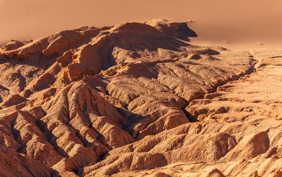 Aerial view of the rugged rock formations and sand dunes of the Valley of the Moon in the arid desert landscape of San Pedro de Atacama, Antofagasta, Chile.