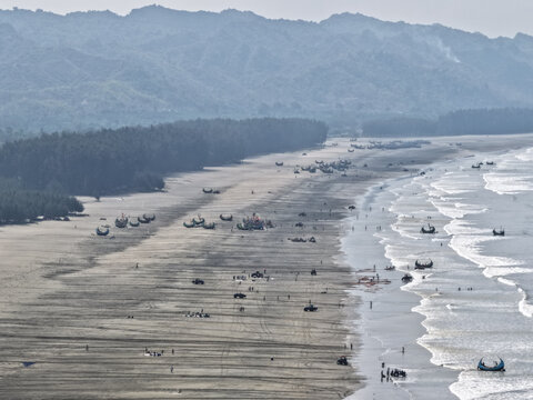 Cox's Bazar, Bangladesh - 10 April 2026: Aerial view of Cox's Bazar Sea Beach with traditional fishing boats on the sand, people, and waves along the coast.