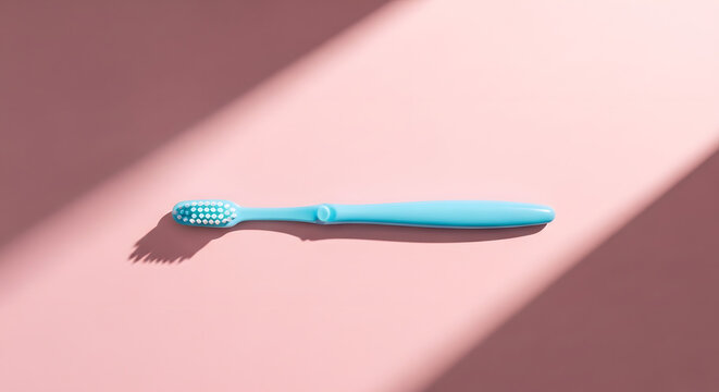 Blue toothbrush on a pink background with soft shadows  