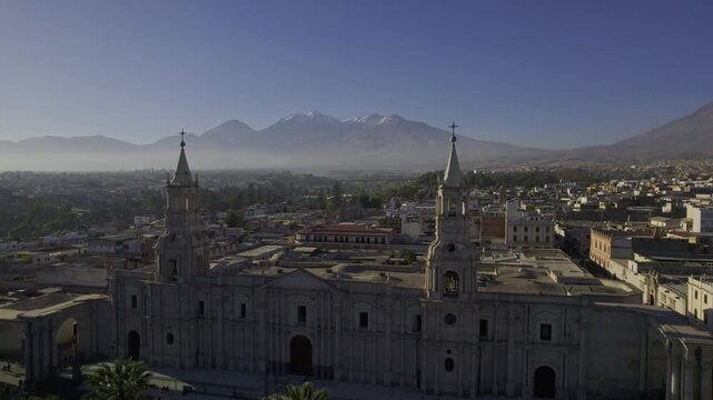 Aerial view of Arequipa Cathedral with its twin towers and colonial architecture, set against the backdrop of the Misti volcano and the city skyline in Arequipa, Arequipa, Peru.