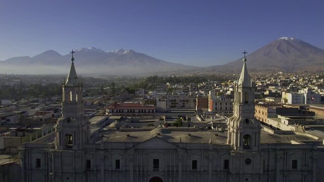 Aerial view of Arequipa Cathedral with its twin towers and the Misti volcano in the background under a clear blue sky in Arequipa, Arequipa, Peru.