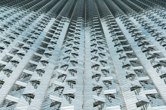 Aerial view of a large greenhouse with repeating glass panels and ventilation windows in Poland.