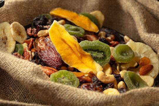 Dried tropical fruits and nuts in burlap bag.