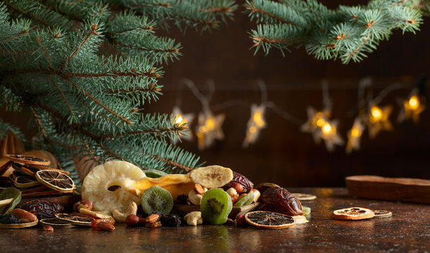 Dried tropical fruits with various nuts and raisins on a old brown table.