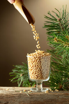 Pine nuts is poured in a glass bowl.