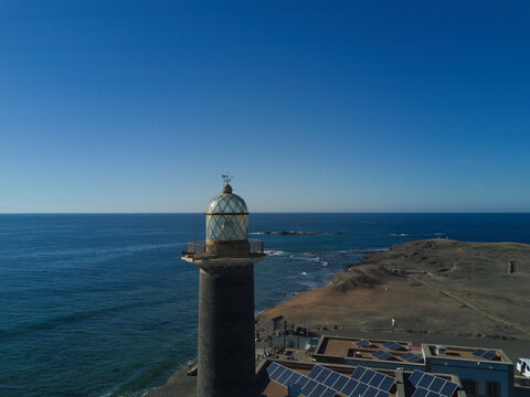 Fuerteventura, Canary Islands, Spain - 09 January 2019: Aerial view of the Punta de Jandia lighthouse with solar panels on adjacent buildings, set against the Atlantic Ocean.
