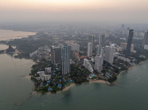 Aerial view of the coastal skyline of Pattaya City featuring modern skyscrapers, lush greenery, and sandy beaches along the Gulf of Thailand in Pattaya City, Chon Buri, Thailand.