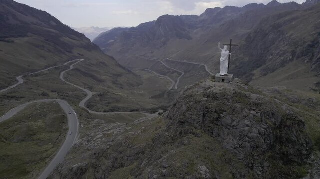 Aerial view of a white statue of Christ overlooking a winding mountain road in the Andes near Chavin de Huantar, Ancash, Peru.