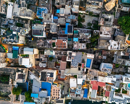 Aerial view of the dense urban fabric of Udaipur, featuring traditional rooftops, narrow streets, and historic architecture in Udaipur, Rajasthan, India.
