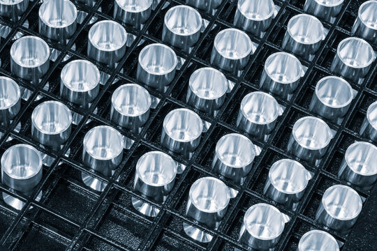 Round metal parts lie in  row for quality control test stand at metalworking plant. tech industrial technology background