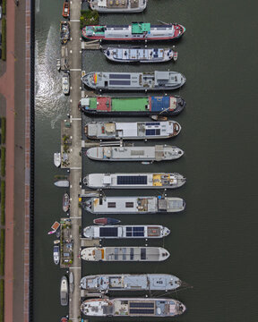Aerial view of IJburg with various houseboats and canal boats moored along a concrete pier in Amsterdam, North Holland, Netherlands.