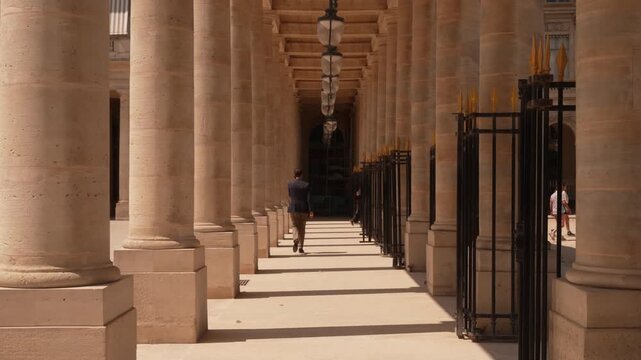 Sunlight falling along a long stone colonnade in Paris