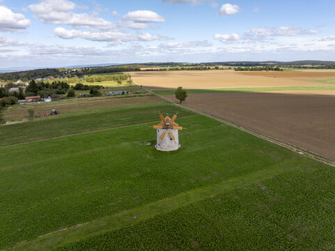Aerial view of the historic Regi Szelmalom windmill surrounded by green fields and agricultural land in Tes, Hungary.