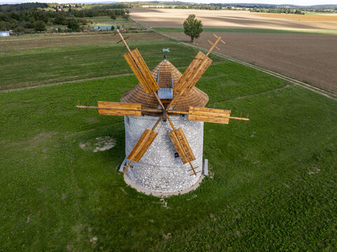 Aerial view of the historic Regi Szelmalom windmill surrounded by green fields and agricultural land in Tes, Hungary.