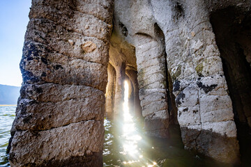Obraz premium Sunlight filtering through Crowley Lake Stone Columns along shoreline in Mono County California
