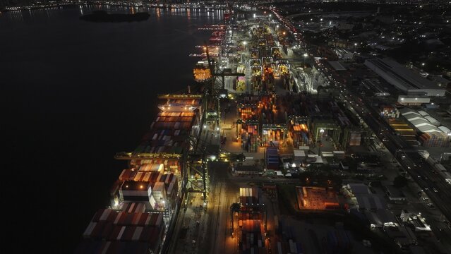 Rio de Janeiro, Brazil - 17 June 2026: Aerial view of Porto do Rio de Janeiro at night with illuminated container ships, cranes, and rows of shipping containers along the waterfront.