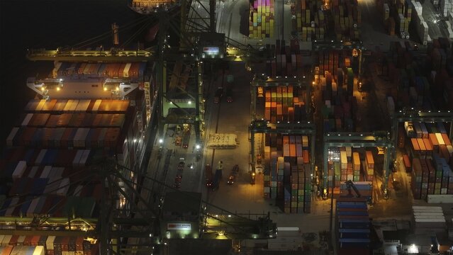Rio de Janeiro, Brazil - 17 June 2026: Aerial view of Porto do Rio de Janeiro at night, with a container ship being loaded by gantry cranes amidst stacks of colorful shipping containers.