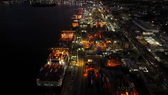 Rio de Janeiro, Brazil - 17 June 2026: Aerial view of Porto do Rio de Janeiro at night, showing a large container ship docked at the terminal with illuminated cranes and shipping containers.