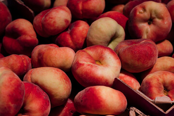 Close up of flat peaches in crates at supermarket produce display. © sav_an_dreas
