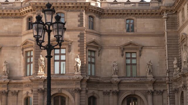 Statues and tall windows on a palace facade in central Paris