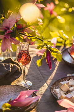 Table setting in garden on sunset light. Table decorated with magnolia flowers under magnolia tree.