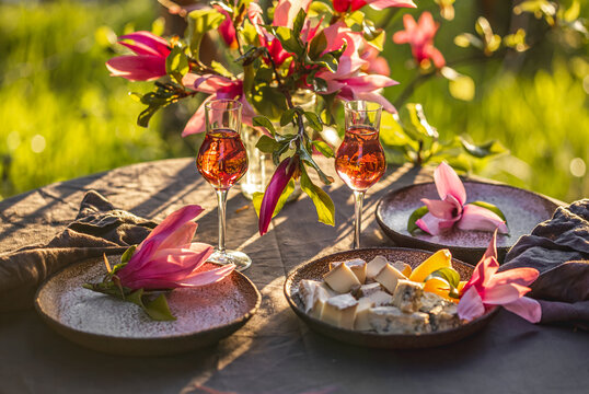 Table setting in garden on sunset light. Table decorated with magnolia flowers under magnolia tree.
