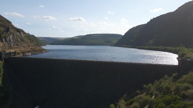 Drone flying over Caban Coch Dam wall in Wales