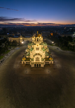 Aerial view of the illuminated Patriarchal Cathedral St. Alexander Nevsky at dusk, with golden domes and neo-Byzantine architecture in Sofia, Sofia City Province, Bulgaria.