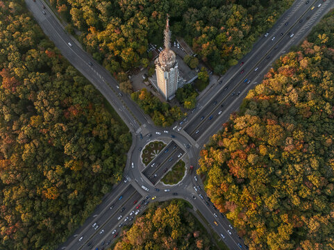 Aerial view of the Sofia Television Tower surrounded by a vibrant autumn forest and a busy road intersection in Sofia, Sofia City Province, Bulgaria.