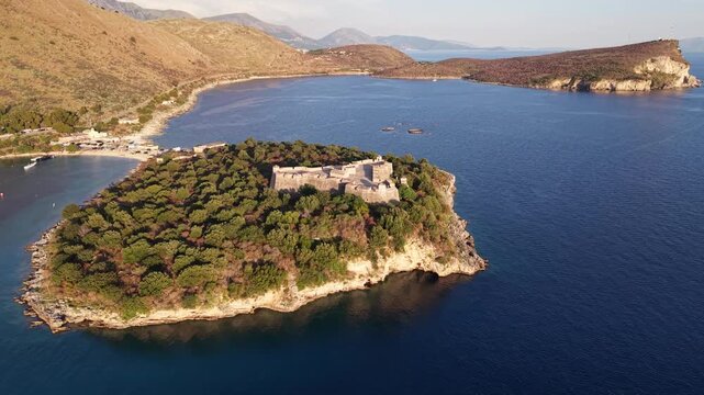 Aerial view of the historic Porto Palermo Castle situated on a peninsula surrounded by the blue waters of the Ionian Sea in Porto Palermo, Qarku i Vlores, Albania.