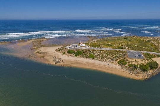 Aerial view of the Vila Nova de Milfontes Lighthouse on a coastal headland where the Mira River meets the Atlantic Ocean, with sandy beaches in Vila Nova de Milfontes, Beja District, Portugal.