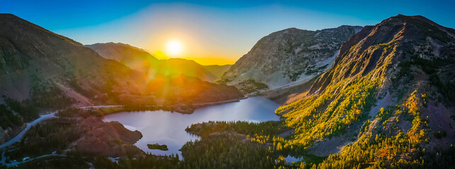 Fototapeta premium Golden sunrise glows over Ellery Lake mountains