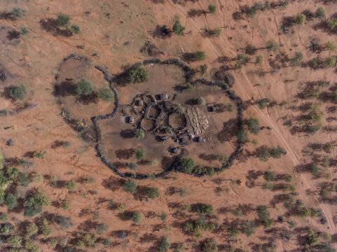 Aerial view of a traditional Samburu manyatta settlement with circular enclosures surrounded by arid landscape and sparse trees near Oldoinyo Sabachi in Archers Post, Samburu County, Kenya.