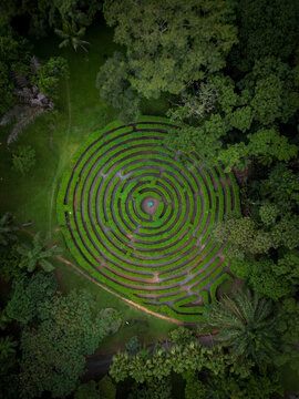 Aerial view of a circular hedge maze surrounded by lush green trees and parkland in Jaragua do Sul, Santa Catarina, Brazil.