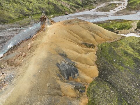 Aerial view of Landmannalaugar with colorful rhyolite mountains, volcanic terrain, and a winding river Hella, Rangarthing ytra, Iceland.