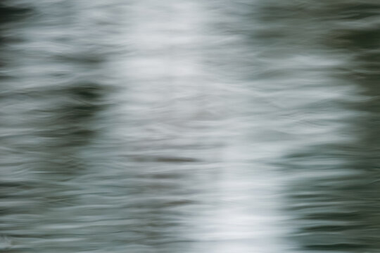 Abstract background resembling brushed metal steel or luxury satin silk fabric. Soft fluid texture with silver reflections and horizontal lines. Artistic long exposure ripples water surface background