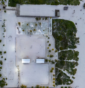 Aerial view of beach sports courts with sand playing fields, palm trees, and small structures in Progreso, Yucatan, Mexico.