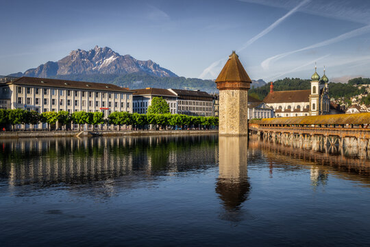 View of the historic Chapel Bridge and Water Tower spanning the Reuss River with the snow-capped Mount Pilatus in the background in Lucerne, Lucerne, Switzerland.